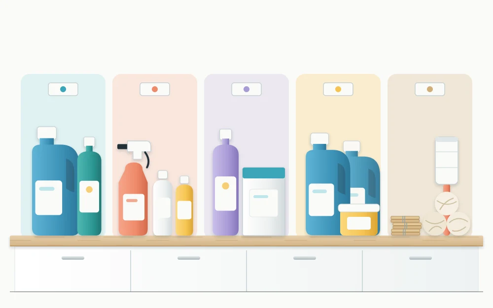 Laundry supplies set out on a counter in five loose groups, bottles upright and accessories such as dryer balls and clothespins together